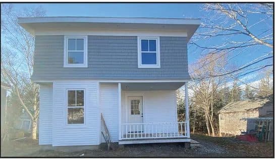 Freshly rebuilt grey and white two-story house on a winter day