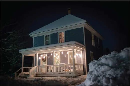 Renovated downtown house lit up at night in deep snow