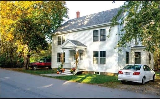 White clapboard Dyer House duplex on a village street
