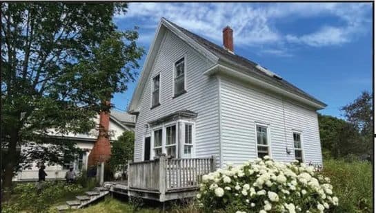 White farmhouse rental with hydrangeas